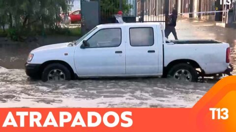 Dos autos quedan atrapados en una calle inundada
